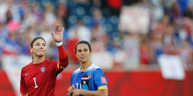 United States goalkeeper Hope Solo (1) waves to the crowd next to teammate Carli Lloyd (10) after their draw against Sweden in FIFA Women's World Cup soccer game action in Winnipeg, Manitoba, Canada, Friday, June 12, 2015. (John Woods/The Canadian Press via AP) MANDATORY CREDIT