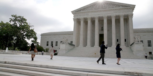 WASHINGTON, DC - JUNE 18: People gather in front of the Supreme Court Building June 18, 2015 in Washington, DC. This month the high court is expected to hand down its ruling on gay marriage and Obamacare subsidies. (Photo by Mark Wilson/Getty Images)