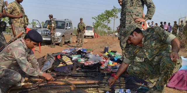 Indian policemen inspect arms and ammunition recovered from Maoist rebels after an encounter in Palamau district in Jharkhand state, India, Tuesday, June 9, 2015. Indian police said they killed at least 12 Maoist rebels in a clash early Tuesday in one of their strongholds in eastern India.(Press Trust of India via AP) INDIA OUT