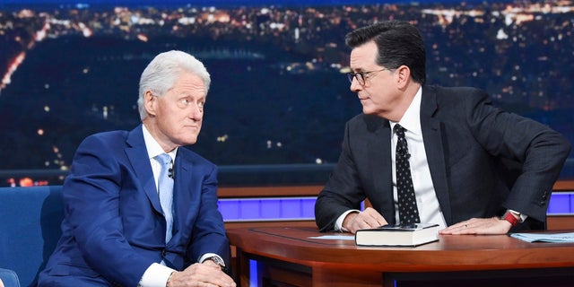 Former President Bill Clinton, left, appears with host Stephen Colbert while promoting his book 'The President is Missing,' on 'The Late Show with Stephen Colbert,' Tuesday, June 5, 2018 in New York.