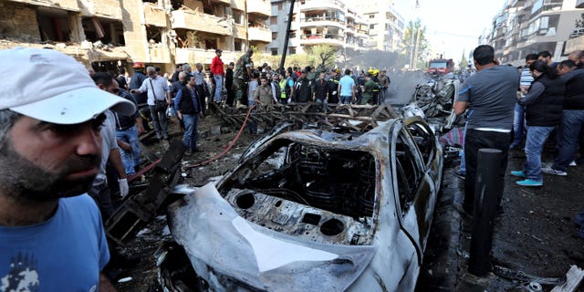 FILE - In this Nov. 19, 2013, file photo, people gather at the scene where two deadly explosions struck near the Iranian Embassy in Beirut, Lebanon. Lebanese authorities said Friday, Jan. 3, 2014, that DNA tests have confirmed that a man in government custody, Majid al-Majid, is the alleged leader of the Abdullah Azzam Brigades, an al-Qaida-linked group that has claimed responsibility for the attack on the embassy. Al-Majid is one of the 85 most-wanted individuals in his native Saudi Arabia. (AP Photo/Bilal Hussein, File)