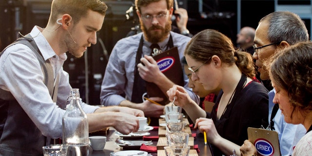 Barista competitor Nick Purvis, left, of Santa Barbara, Calif., presents one of his brewed entries to a panel of judges at the annual United States Barista Championship in Boston.