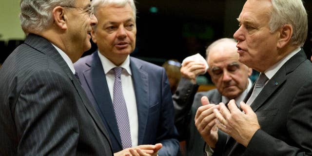 Cypriot Foreign Minister Ioannis Kasoulides, left, speaks with, from left, Belgian Foreign Minister Didier Reynders, Malta's Foreign Minister George Vella and French Foreign Minister Jean-Marc Ayrault during a round table meeting of EU foreign ministers at the EU Council building in Brussels on Monday, Dec. 12, 2016. EU foreign ministers hold talks Monday on the conflict in Syria, relations with Africa and migration. (AP Photo/Virginia Mayo)