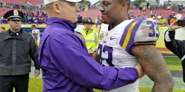 FILE - In this jan. 1, 2014 file photo, LSU head coach Les Miles, left, congratulates MVP Jeremy Hill (33) after LSU defeated Iowa 21-14 in the Outback Bowl NCAA college football game in Tampa, Fla. LSU leading rusher Jeremy Hill says he's decided to enter the NFL draft. In an announcement made Monday, jan. 13, 2014, on a social media website, Hill says he's grateful to LSU fans, friends, coaches and family and his decision was "very difficult." (AP Photo/Chris O'Meara, File)