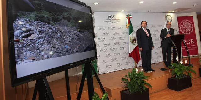 FILE - In this Dec. 7, 2014, file photo, Mexico's Attorney General, Jesus Murillo Karam, right, flanked by Tomas Zeron director of Mexico's Criminal Investigation Agency, speaks during a news conference in Mexico City. The Attorney General’s Office has announced on Wednesday, Sept. 14, 2016, the resignation of Tomas Zeron, whose dismissal had been demanded by the families of 43 college students who disappeared two years ago. (AP Photo/Marco Ugarte, File)