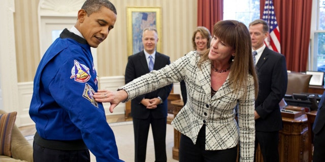 Nov. 1, 2011: Janet Kavandi, Director of Flight Crew Operations at Johnson Space Center, presents President Obama with a jacket during a drop by with the crew of the Space Shuttle Atlantis in the Oval Office.