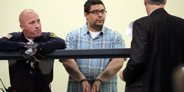 Carlos Colina, center, speaks with his attorney John Cunha, Jr., right, during his arraignment in Cambridge District Court in Medford, Mass., Monday, April 6, 2015. Colina was charged with being an accessory after the crime of assault and battery causing serious bodily injury and the improper disposal of human remains, after the discovery of human remains in Cambridge on Saturday. (AP Photo/The Boston Herald, Chitose Suzuki, Pool)