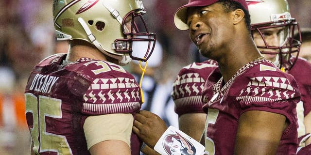 Suspended Florida State quarterback Jameis Winston, right, talks to tight end Nick O'Leary during a timeout in the second half of an NCAA college football game against Clemson in Tallahassee, Fla., Saturday, Sept. 20, 2014. Florida State won 23-17 in overtime. (AP Photo/Mark Wallheiser)
