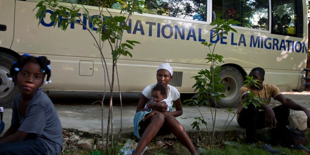 FILE - In this Nov. 24, 2013, file photo, Mona Fleurisme 20, holds her 3-month-old son Rotelson as they wait to be taken to their hometown, together with other Haitians after being deported by Dominican Republic authorities, in Croix-des-Bouquets, Haiti. Jean Baptiste Saint-Cyr, director of Haiti’s National Identification Office, has announced an effort to register Haitian immigrants, who live without documentation in the neighboring Dominican Republic as well as Turks and Caicos. (AP Photo/Dieu Nalio Chery, File)