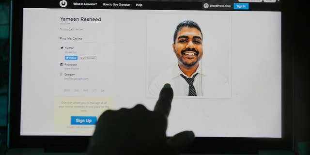 A Sri Lankan woman points to a portrait of Maldivian blogger Yameen Rasheed on his blog "The Daily Panic" in Colombo, Sri Lanka, Sunday, April 23, 2017. Police in the Maldives said in a statement that Rasheed was found Sunday morning with multiple stab wounds in a house in the capital, Male. He died at a hospital. (AP Photo/Eranga Jayawardena)