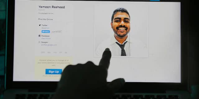 A Sri Lankan woman points to a portrait of Maldivian blogger Yameen Rasheed on his blog "The Daily Panic" in Colombo, Sri Lanka, Sunday, April 23, 2017. Police in the Maldives said in a statement that Rasheed was found Sunday morning with multiple stab wounds in a house in the capital, Male. He died at a hospital. (AP Photo/Eranga Jayawardena)