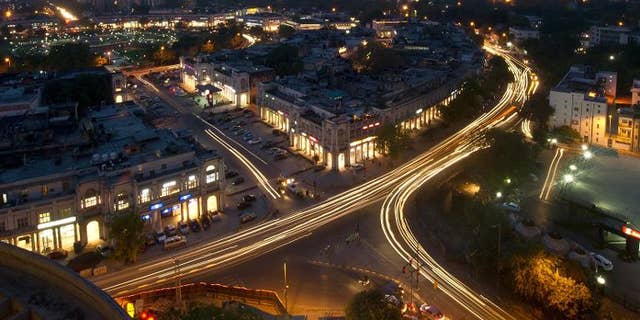 This photograph taken on April 18, 2013 shows the Indian capital's skyline as traffic drives around the outer circle of Connaught Place in the heart of New Delhi