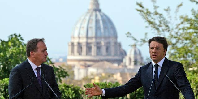 Italian Premier Matteo Renzi, right, and Swedish Prime Minister Stefan Lofven, backdropped by the St. Peter's Basilica, talk to journalists during a press conference at the end of their meeting, at Rome's Villa Panphilii, Wednesday, July 6, 2016. (AP Photo/Andrew Medichini)