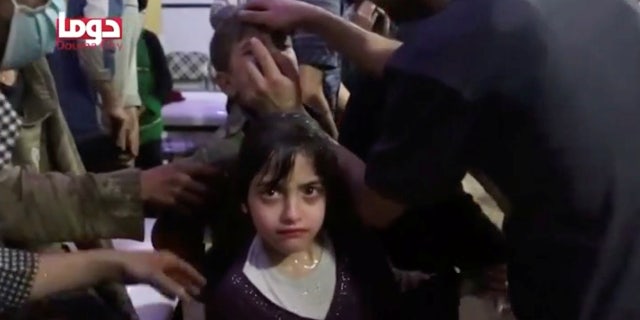 April 8: A girl looks on following alleged chemical weapons attack, in what is said to be Douma, Syria