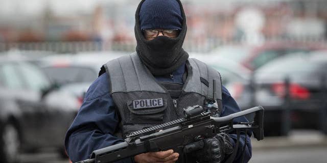 An elite police officer patrols at Orly airport, south of Paris, Saturday, March, 18, 2017. A man was shot to death Saturday after trying to seize the weapon of a soldier guarding Paris' Orly Airport, prompting a partial evacuation of the terminal, police said. (AP Photo/Kamil Zihnioglu)