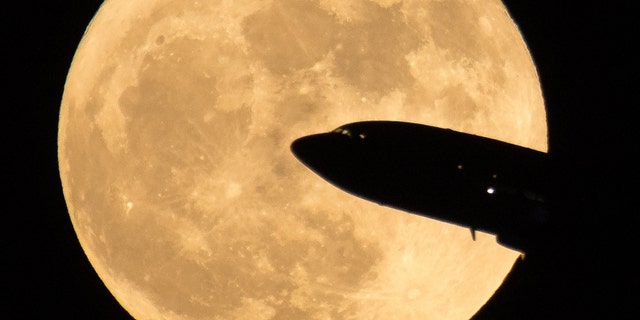 File photo - A plane taking off from Ronald Reagan National Airport passes in front of the Moon as it rises on Sunday, December 3, 2017 in Washington.