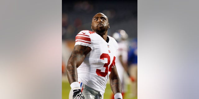 New York Giants running back Brandon Jacobs makes a face at fans before the Giants' NFL football game against the Chicago Bears, Thursday, Oct. 10, 2013, in Chicago. (AP Photo/Charles Rex Arbogast)