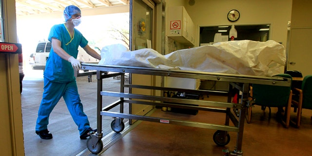Aug. 10, 2012: In this photo, a morgue staff member brings in the body of a suspected illegal immigrant found in the Arizona desert, at the Pima County morgue in Tucson, Ariz.