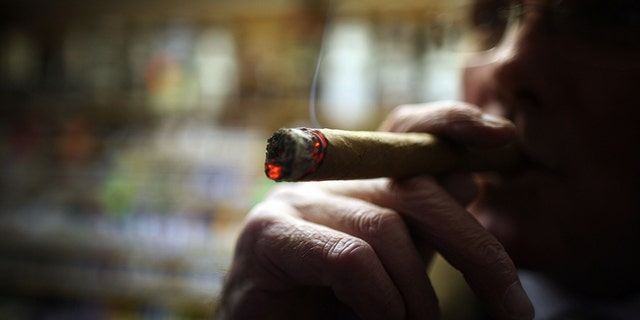 LIVERPOOL, UNITED KINGDOM - DECEMBER 09: Cigar lover Paul Clarke samples a Havana cigar in Turmeau's, Liverpool's last remaining tobacconist shop.