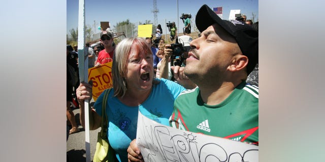 An unidentified protester, left, argues with American citizen Lupillo Rivera, brother of Mexican-American singer Jenni Rivera.