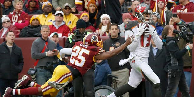 Tampa Bay Buccaneers wide receiver Mike Evans (13) pulls in a touchdown pass under pressure from Washington Redskins free safety Ryan Clark (25) during the second half of an NFL football game in Landover, Md., Sunday, Nov. 16, 2014. (AP Photo/Alex Brandon)