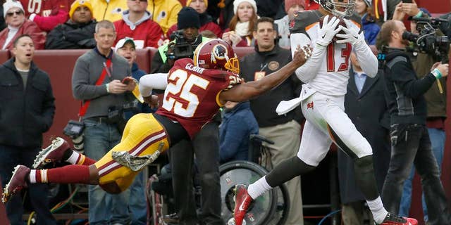 Tampa Bay Buccaneers wide receiver Mike Evans (13) pulls in a touchdown pass under pressure from Washington Redskins free safety Ryan Clark (25) during the second half of an NFL football game in Landover, Md., Sunday, Nov. 16, 2014. (AP Photo/Alex Brandon)