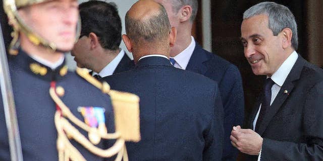 FILE - In this June 2, 2015 file photo chief of protocol at the French presidential palace, Laurent Stefanini, right, speaks with an unidentified person at the Elysee Palace in Paris. France’s government has named a respected diplomat who is said to be gay as the country’s ambassador to UNESCO, several months after he was nominated as ambassador to the Vatican _ a job he never started. (AP Photo/Remy de la Mauviniere, File)