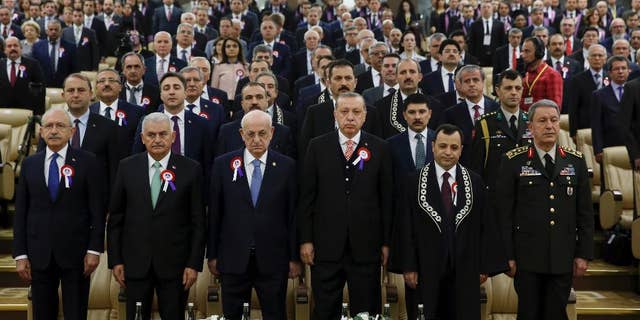Turkey's President Recep Tayyip Erdogan, 4th left, accompanied by, from left to right, Kemal Kilicdaroglu, leader of the Republican People's Party (CHP), Prime Minister Binali Yildirim, Ismail Kahraman, Speaker of the Grand National Assembly of Turkey, Turkish Constitutional Court Chairman Zuhtu Arslan and Chief of the General Staff of the Turkish Armed Forces, Hulusi Akar, attend a ceremony as part of the 55th anniversary of the founding of Turkey's Constitutional Court, in Ankara, Turkey, on Tuesday, April 25, 2017. Legislators representing Europe's top human rights body, the Strasbourg-France-based Parliamentary Assembly of the Council of Europe, on Tuesday voted in favour of re-opening monitoring procedures in Turkey in a move that reflects its strong concern over the functioning of democratic institutions in the country.(Press Presidency Press Service Pool Photo via AP)