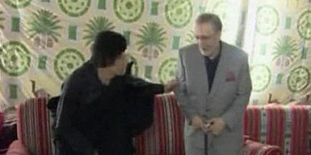 Convicted Lockerbie bomber Abdel Basset al-Megrahi (R) sits with Libyan leader Muammar Gaddafi in Tripoli in this August 21, 2009 video grab from Libya TV. Gaddafi hugged the convicted Lockerbie bomber and promised more cooperation with Britain in gratitude for his release, while London and Washington condemned his "hero's welcome" home. Meeting Megrahi and his family late on Friday, Gaddafi thanked British Prime Minister Gordon Brown and Queen Elizabeth for "encouraging" Scotland to release the dying prisoner from a Scottish jail, Libyan news agency JANA reported. REUTERS/Libya TV via REUTERS TV (LIBYA POLITICS CONFLICT) NO SALES. NO ARCHIVES. FOR EDITORIAL USE ONLY. NOT FOR SALE FOR MARKETING OR ADVERTISING CAMPAIGNS. LIBYA OUT. NO COMMERCIAL OR EDITORIAL SALES IN LIBYA