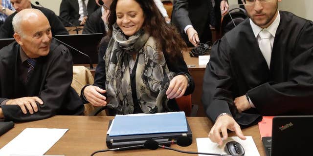 Terror suspect Beate Zschaepe arrives at the court room besides her lawyers Hermann Borchert, left, and Mathias Grasel in Munich, Germany, Thursday, Sept. 29, 2016. Zschaepe is accused of being involved in 10 neo-Nazi murders of the National Socialist Underground group, which allegedly killed eight Turkish men, a Greek and a policewoman between 2000 and 2007. (AP Photo/Matthias Schrader)