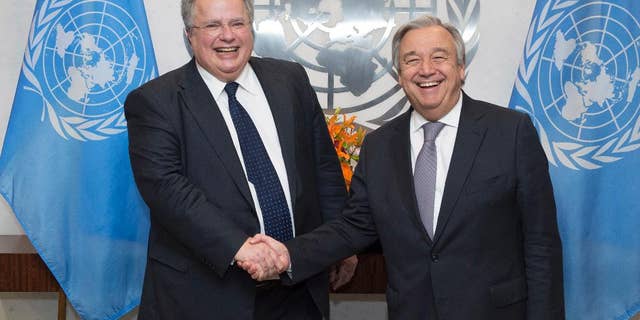 In this photo provided by the United Nations, U.N. Secretary-General Antonio Guterres, right, shakes hands with Greek Foreign Minister Nikos Kotzias at U.N. headquarters, Friday, Jan. 6, 2017. (Eskinder Debebe/The United Nations via AP)