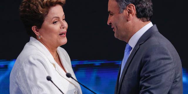 Brazil's President Dilma Rousseff, presidential candidate for re-election of the Workers Party, PT , left, shakes hands with Aecio Neves, presidential candidate of the Brazilian Social Democracy Party, PSDB, at the end of a presidential debate in Sao Paulo, Brazil, Tuesday, Oct. 14, 2014. Rousseff and Neves will face each other in a presidential runoff on Oct. 26. (AP Photo/Andre Penner)