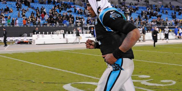 Carolina Panthers' Cam Newton (1) runs off the field after an NFL football game against the New Orleans Saints in Charlotte, N.C., Thursday, Oct. 30, 2014. The Saints won 28-10. (AP Photo/Mike McCarn)