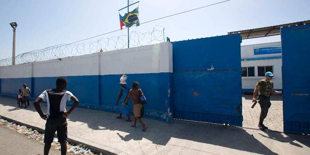 In this Aug. 16, 2016 photo, a Brazilian U.N. peacekeeper opens a gate at the U.N. base in the Cite Soleil slum of Port-au-Prince, Haiti. According to an AP investigation, some 150 allegations of abuse and exploitation were reported in Haiti between 2004 and 2016. The allegations involved U.N. peacekeepers and other personnel. Alleged victimizers came from Bangladesh, Brazil, Jordan, Nigeria, Pakistan, Uruguay and Sri Lanka, according to U.N. data and interviews. More countries may have been involved, but the United Nations only started disclosing alleged perpetrators’ nationalities after 2015. (AP Photo/Dieu Nalio Chery)