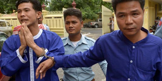 Born Samnang (left) and Sok Sam Oeun (right) are escorted by a prison guard to the Supreme Court in Phnom Penh, on September 25, 2013.