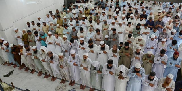 People offer funeral prayers for Taliban leader Mullah Mohammad Omar at a mosque in Peshawar, Pakistan, Friday, July 31, 2015. Afghanistan's Taliban on Thursday confirmed the death of Mullah Omar, who led the group's self-styled Islamic emirate in the 1990s, sheltered al-Qaida through the 9/11 attacks and led a 14-year insurgency against U.S. and NATO troops. (AP Photo/Mohammad Sajjad)