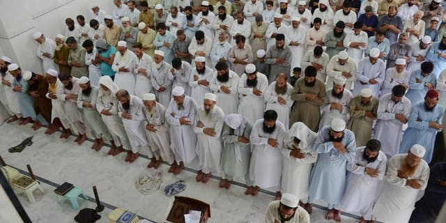 People offer funeral prayers for Taliban leader Mullah Mohammad Omar at a mosque in Peshawar, Pakistan, Friday, July 31, 2015. Afghanistan's Taliban on Thursday confirmed the death of Mullah Omar, who led the group's self-styled Islamic emirate in the 1990s, sheltered al-Qaida through the 9/11 attacks and led a 14-year insurgency against U.S. and NATO troops. (AP Photo/Mohammad Sajjad)