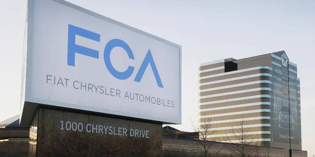 FILE - This Tuesday, May 6, 2014, file photo shows a sign outside Fiat Chrysler Automobiles world headquarters in Auburn Hills, Mich. Fiat Chrysler and Google said Tuesday, April 25, 2017, for the first time will offer rides to the public in the self-driving automobiles they are building under an expanding partnership. (AP Photo/Carlos Osorio, File)
