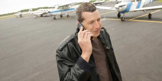 April 20, 2011: Commercial pilot Bill Phillips uses his cellphone on the tarmac at North Little Rock municipal Airport in North Little Rock, Ark.