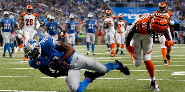 Detroit Lions wide receiver Calvin Johnson (81) catches a 27-yard touchdown reception as Cincinnati Bengals cornerback Dre Kirkpatrick (27) defends in the second half of an NFL football game on Sunday, Oct. 20, 2013, in Detroit. (AP Photo/Rick Osentoski)