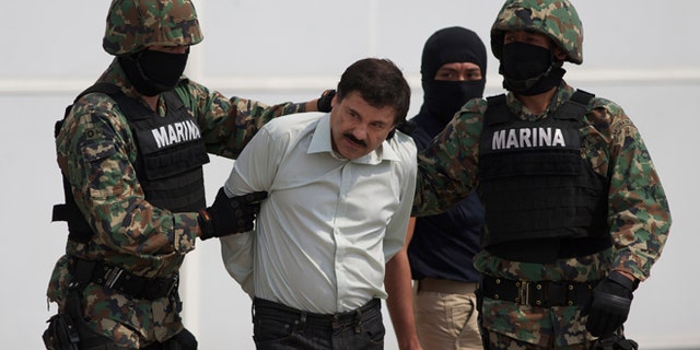 Joaquin "El Chapo" Guzman is escorted to a helicopter in Mexico City, Saturday, Feb. 22, 2014.
