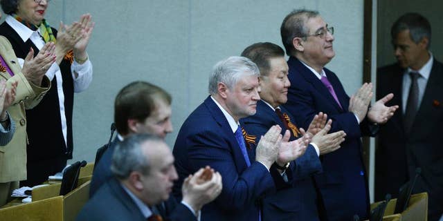 Members of the State Duma, lower parliament chamber, applaud for their voting during a plenary session in Moscow, Russia, Thursday, March 20, 2014. The Kremlin-controlled State Duma voted Thursday to allow Crimea to join Russia following a quick discussion in which members of the Kremlin-controlled chamber assailed the Ukrainian authorities. The merger needs to be rubber stamped by the upper house and signed by President Vladimir Putin, mere formalities expected to be completed by the end of the week. (AP Photo/Alexander Zemlianichenko)