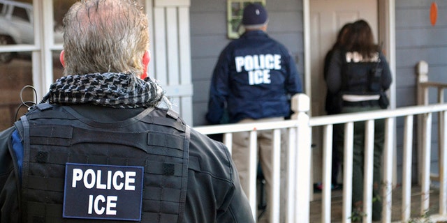 In this Feb. 9, 2017, file photo provided by U.S. Immigration and Customs Enforcement, ICE agents stand outside a home in Atlanta during a targeted enforcement operation aimed at immigration fugitives, re-entrants and at-large criminals living in the country illegally.