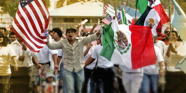 Protestors wave American, Mexican and Guatemalan flags as thousands march at an immigration rally in Homestead, Fla. as part of a planned national day of economic protests, boycotting work, school and shopping to show the importance on immigrants to the country Monday, May 1, 2006. (AP Photo/Lynne Sladky)