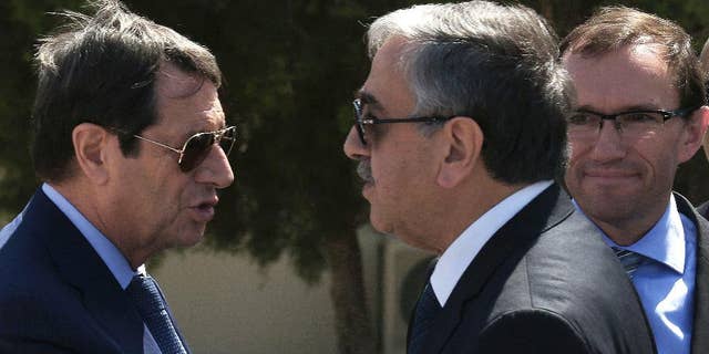 FILE- In this Wednesday, Sept. 14, 2016 file photo, Cypriot President Nicos Anastasiades, left, and breakaway Turkish Cypriot leader Mustafa Akinci, right, talks as the UN Special Advisor of the Secretary-General Espen Barth Eide, right, looks on as they leave their talks aimed at reunifying the ethnically divided island, at the disused Nicosia airport inside a United Nations controlled buffer zone. Cyprus’ president said Friday, Sept. 30, 2016, an insistence by breakaway Turkish Cypriots to cede Turkey the right to militarily intervene under a hoped-for deal reunifying the divided Mediterranean island nation is “excessive and unjustified.” (AP Photo/Petros Karadjias, File)