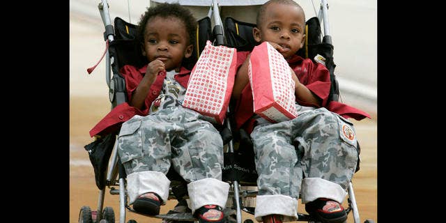 Twin brothers Chance, left, and Choice Scott enjoy their popcorn while campaigning for Democratic gubernatorial candidate Jim Davis with friends in Jupiter, Fla. Tuesday, Nov. 7, 2006. Davis is running against Republican candidate Charlie Crist. (AP Photo/Lynne Sladky)