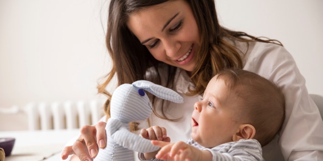 Mother and her baby playing with Bunny toy.