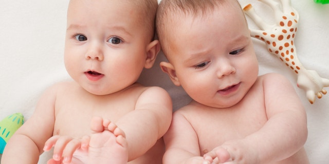 young twins are touching their little feet