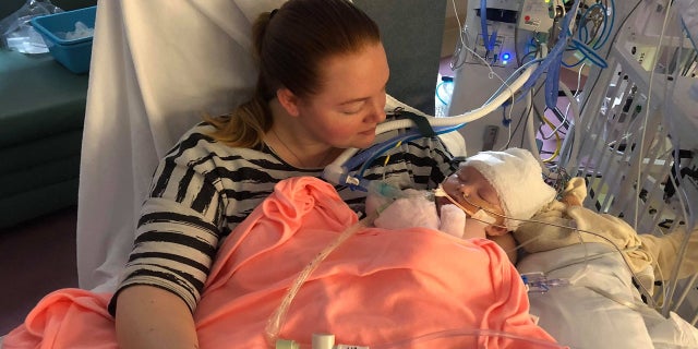 Baby McKenna Hovenga is held in the arms of her mother Kassy on Mother's Day. The infant is showing signs of improvement after an overthrown softball hit her head at her father's game earlier this month.
