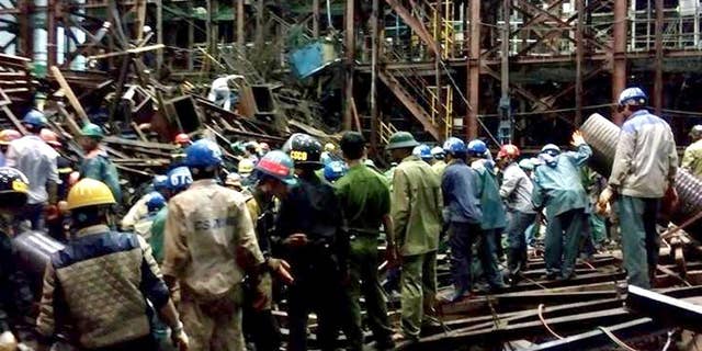 In this Wednesday March 25, 2015 photo, rescuers work through the rubble trying to find survivors after scaffolding collapsed in an economic zone in Ha Tinh province in central Vietnam. Police says at least 14 people were killed and 28 others were injured in the incident. (AP Photo/Vietnam News Agency, Cong Tuong)